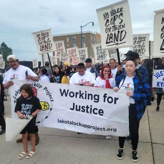 People marching with Lakota LockUp Banner, Rapid City, South Dakota, July 4, 2023